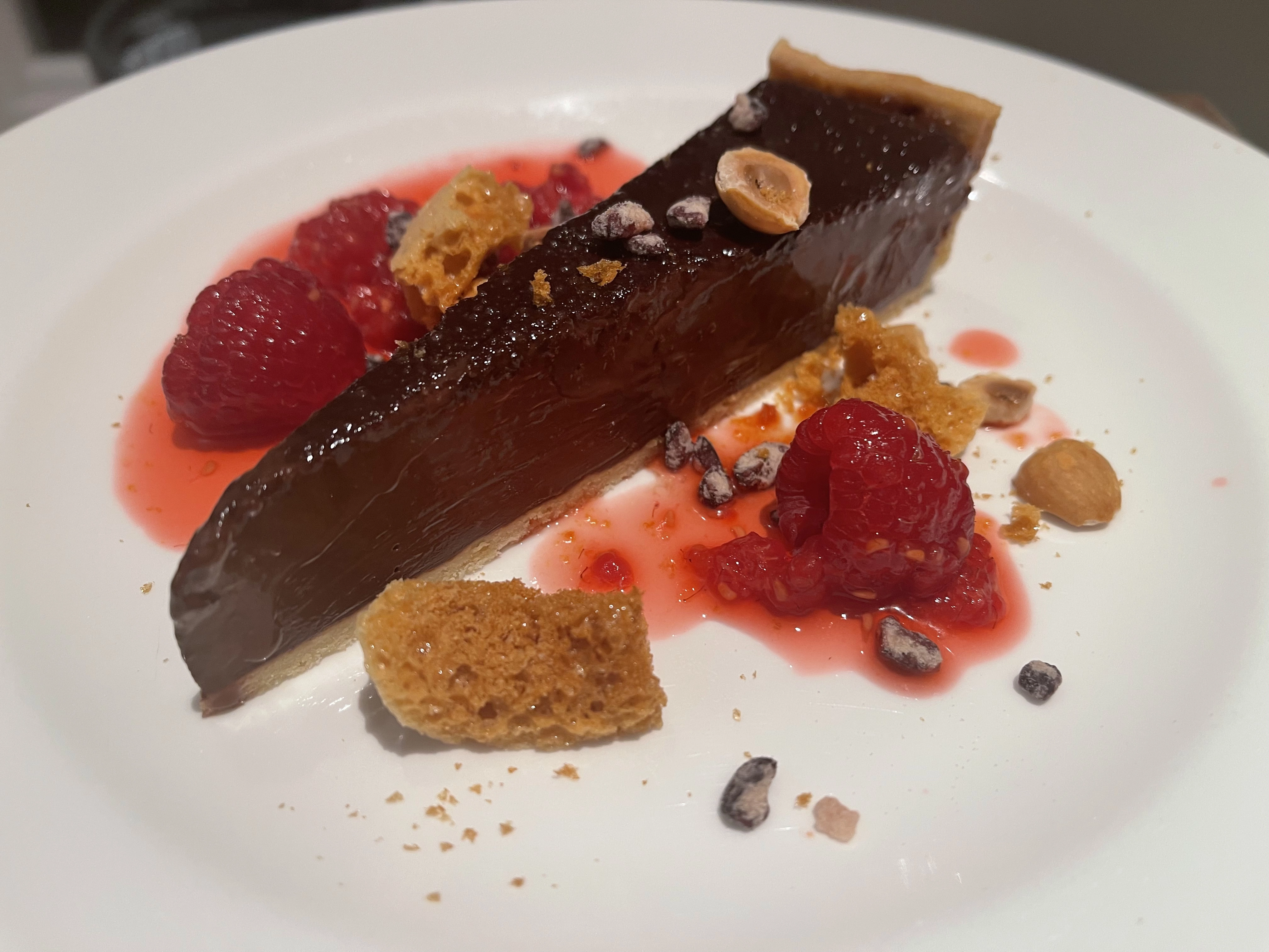 Dark Chocolate Tart Poached Raspberries, Honeycomb, Toasted Hazelnuts & Cacao 