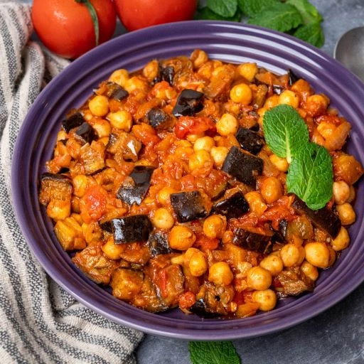 Lebanese Mousakaa Plant Based (V). Aubergine And Chickpea Bake In Tangy Tomato And Sweet Pepper Sauce 